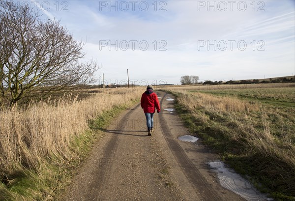 Model released woman walking along country track, Butley, Suffolk, England, UK