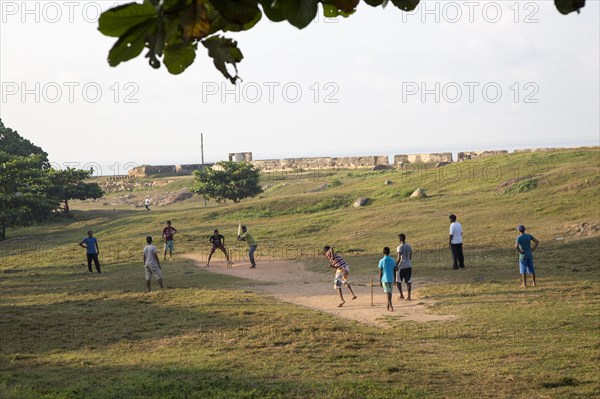 Young men playing an informal game of cricket in the historic town of Galle, Sri Lanka, Asia