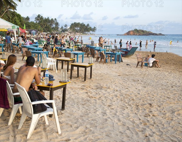 People sitting at tables of beach bar, Mirissa, Sri Lanka, Asia