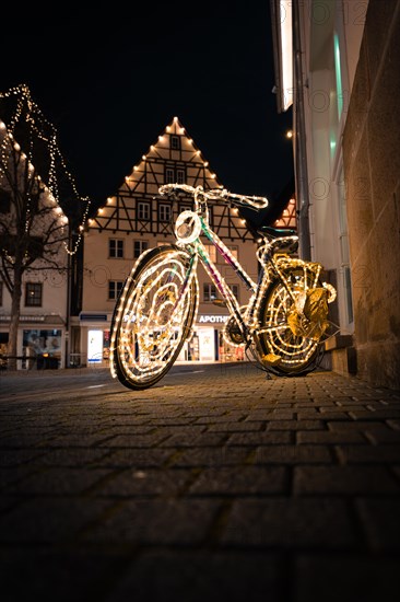 Luminous bicycle with fairy lights in front of a half-timbered house at night, Nagold, Black Forest, Germany, Europe