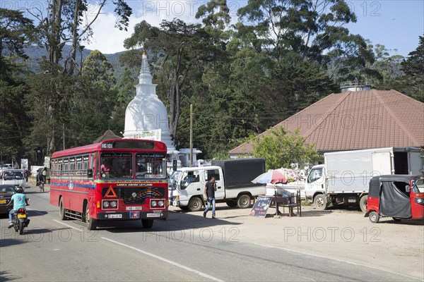 Red local bus passing Buddhist temple stupa, Nuwara Eliya, Sri Lanka, Asia, Sri Lanka, Asia