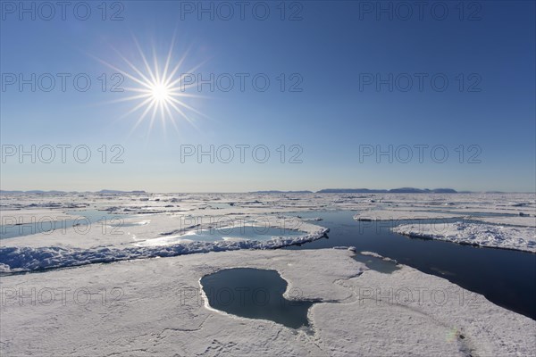 Midnight sun over the Arctic Ocean with drifting ice floes, north of the Arctic Circle at Nordaustlandet, Svalbard, Spitsbergen, Norway, Europe