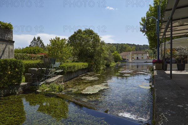Small canal with weir and mill wheel in Goudargues, Departement Gard, Occitanie region, France, Europe