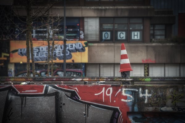 Street cone in the foreground with blurred graffiti in the background, Wuppertal Elberfeld, North Rhine-Westphalia, Germany, Europe