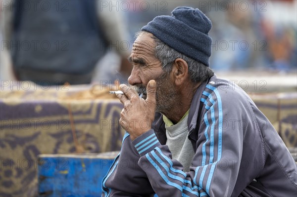 Portrait, Man smoking a cigarette, Harbour, Essaouira, Morocco, Africa