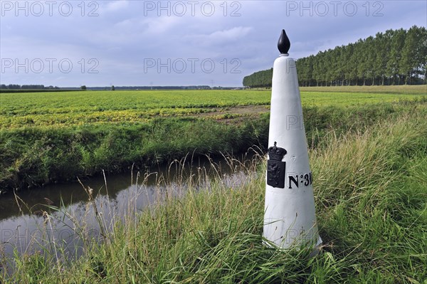 White boundary, border post between the Netherlands and Belgium in polder, Meetjesland