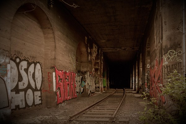 Abandoned tunnel with tracks and colourful graffiti on the walls, former Rethel railway branch, Lost Place, Flingern, Duesseldorf, North Rhine-Westphalia, Germany, Europe