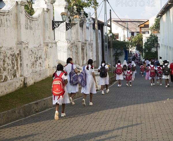 School girls in uniform walking in a street in the historic town of Galle, Sri Lanka, Asia
