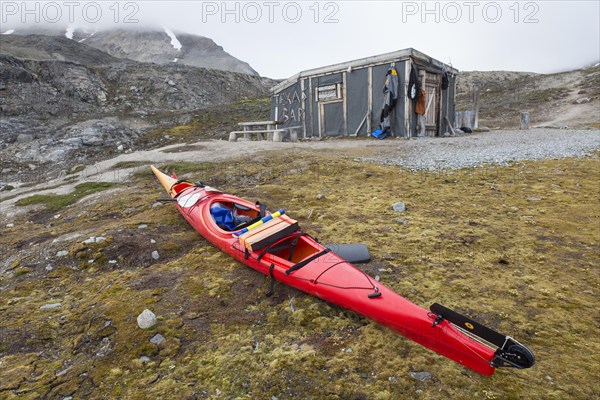 Sea kayaker using Texas Bar as shelter, old fur trapper cabin at Worsleyhamna, Liefdefjorden, Liefdefjord, Svalbard, Spitsbergen, Norway, Europe