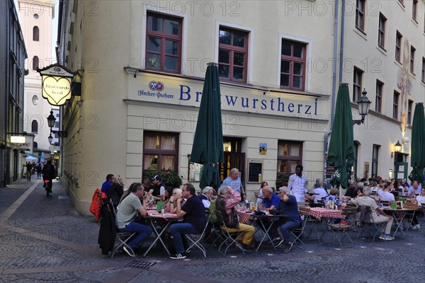 People sitting in the garden in front of the traditional restaurant Bratwurstherzl at Viktualienmarkt, Munich, Bavaria, Germany, Europe