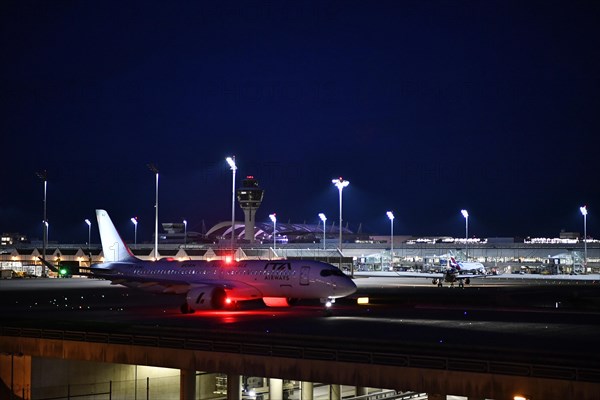 ITA Airways Airbus A220-300 taxiing on taxiway at night, Munich Airport, Upper Bavaria, Bavaria, GermanyMunich Airport, Upper Bavaria, Bavaria, GermanyMunich Airport, Upper Bavaria, Bavaria, Germany, Europe