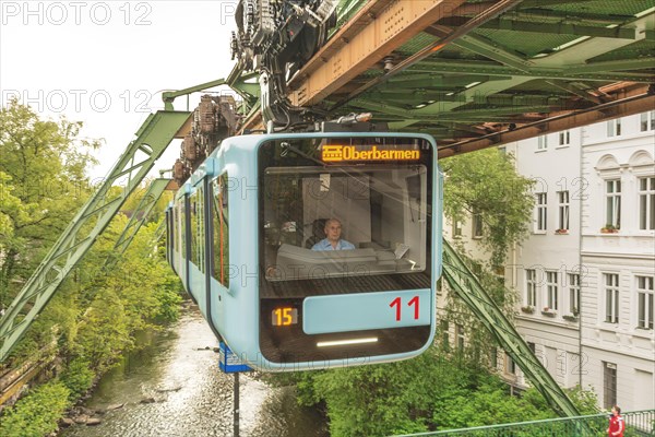 A suspension railway crosses an urban scenery near a suspension bridge, suspension railway, Wuppertal, North Rhine-Westphalia, Germany, Europe