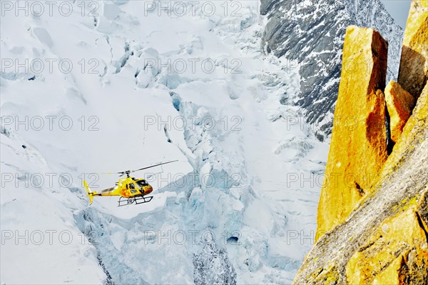 Helicoper with tourists on sightseeing tour flying over the French Alps, France, Europe