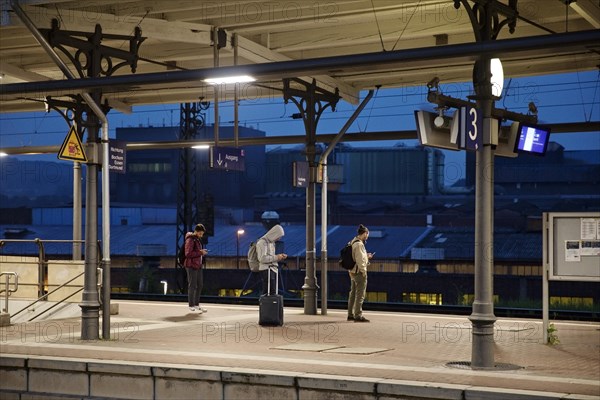 People on the platform early in the morning in front of the stainless steel plant, main railway station, Witten, North Rhine-Westphalia, Germany, Europe