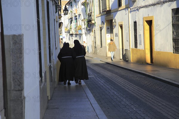 Two nuns walking together along pavement, Cordoba, Spain, Europe