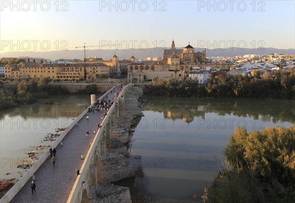 Roman bridge spanning river Rio Guadalquivir with Mezquita cathedral buildings, Cordoba, Spain, Europe