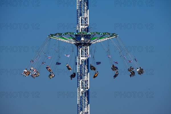 Oktoberfest, afternoon, people having fun in a fairground ride, Munich, Bavaria, Germany, Europe
