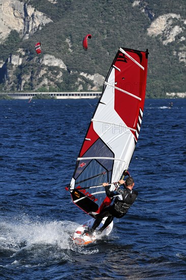 Windsurfers surfing in strong winds on Lake Garda near Malcesine, Veneto, Italy, Europe