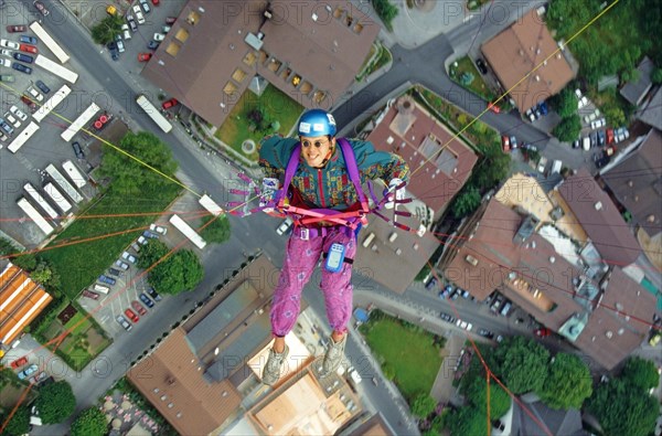 Paragliding pilot with colorful clothes, and small round sunglasses, flying high above Mayrhofen, Tyrole, Austria, bird's eye view, Europe