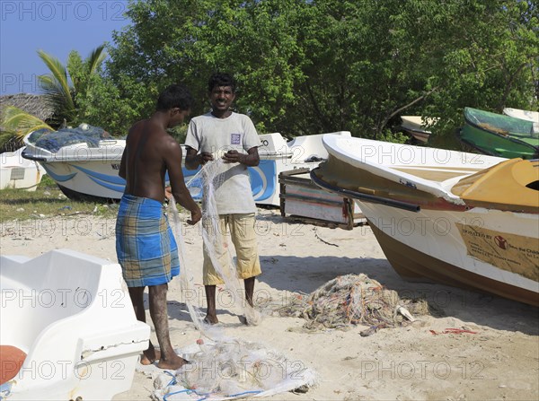 Men with fishing nets on tropical beach at Pasikudah Bay, Eastern Province, Sri Lanka, Asia