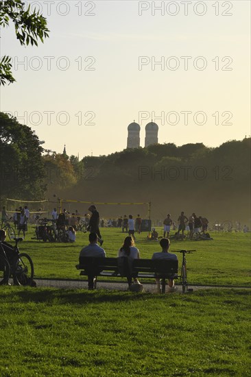 People enjoying the autumn sun on a bench in the English Garden, Munich, Bavaria, Germany, Europe