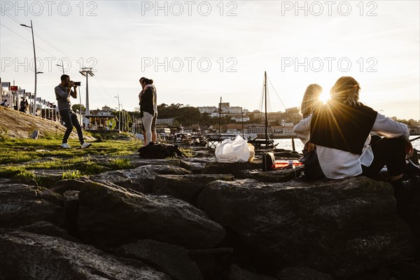 April 17, 2023, Porto, Portugal: Photographer taking photos of the couple by the Douro river