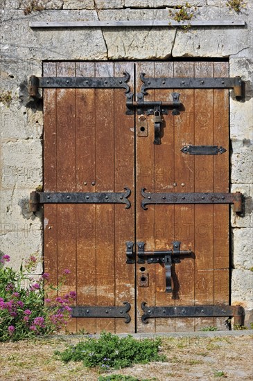 Old wooden door with heavy hinges in the citadel at Le Chateau-d'Oleron on the island Ile d'Oleron, Charente-Maritime, France, Europe