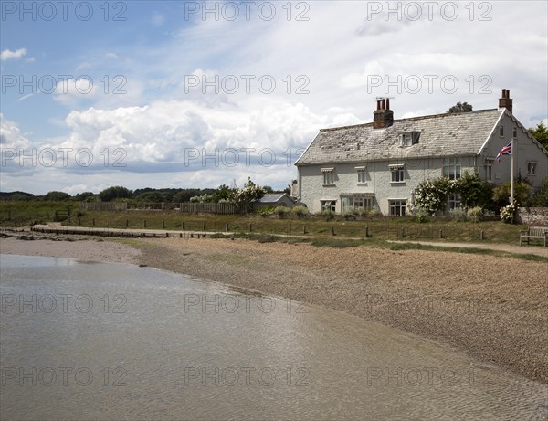House and beach on the River Ore at Orford, Suffolk, England, UK