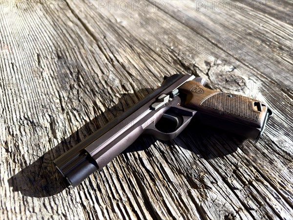 Old Elegant Handgun on an Old Wood Table in a Sunny Day, Made in Switzerland