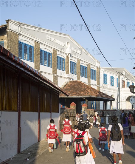 School girls in uniform walking in a street in the historic town of Galle, Sri Lanka, Asia