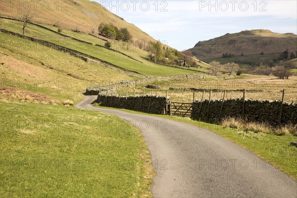 Narrow road and dry stonewall, Boredale valley, Martindale, Lake District national park, Cumbria, England, UK