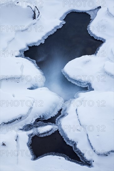 Ice formations formed by frost and freezing cold temperatures over running water of stream
