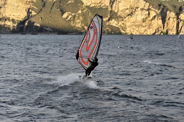 Windsurfers surfing in strong winds on Lake Garda near Malcesine, Veneto, Italy, Europe