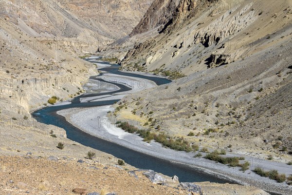 Tsarab River, cutting across the Zanskar Range of the Himalayas in Ladakh, with barren mountains above it, seen on a clear, blue-sky day, late in the summer, when glacier rivers like this one slow down, carry less sediment and become turquoise blue. Kargil District, Union Territory of Ladakh, India, Asia