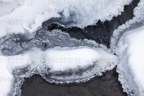 Ice formations formed by frost and freezing cold temperatures over running water of stream