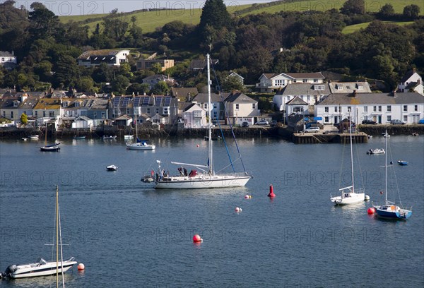 Yachts passing moorings on River Fal, Flushing, Cornwall, England, UK