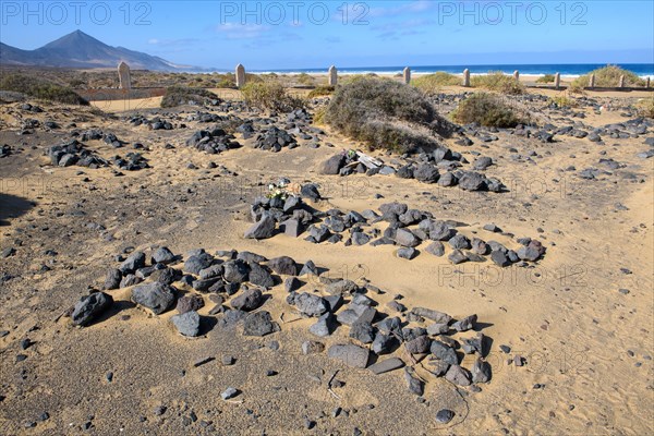 View of old sandy historical cemetery from 1950s with several graves marked by stones from abandoned village of Cofete on west coast of Jandia peninsula, in the background Atlantic Ocean, Cofete, Jandia, Fuerteventura, Canary Islands, Canary Islands, Spain, Europe