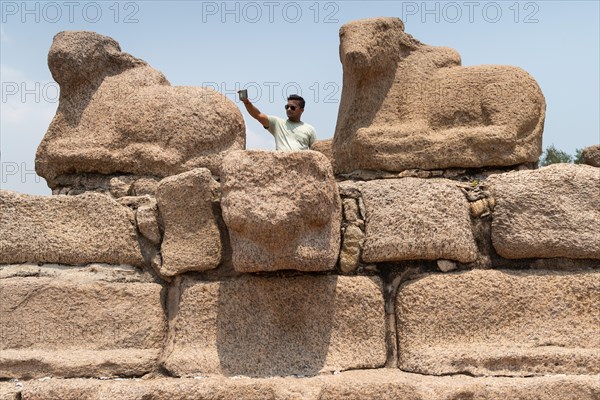 Indian visitor taking selfie, Nandi or Shiva's mount, consecrated Shore Temple, UNESCO World Heritage Site, Mahabalipuram or Mamallapuram, Tamil Nadu, India, Asia