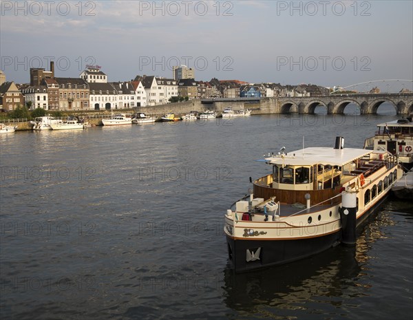 Evening light boats buildings, River Maas or Meuse, Maastricht, Limburg province, Netherlands