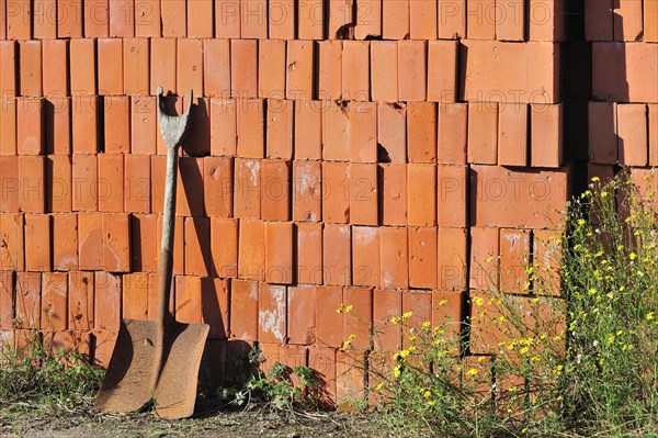 Shovel and pile of stacked red bricks at brickworks, Boom, Belgium, Europe