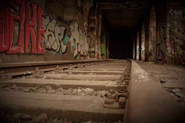 Railway tracks lead into the depths, accompanied by wall graffiti, former railway branch Rethel, Lost Place, Flingern, Duesseldorf, North Rhine-Westphalia, Germany, Europe