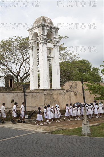 School children in uniform walking in a street in the historic town of Galle, Sri Lanka, Asia