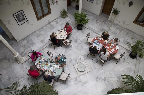 Historic building interior, Hotel Casa Grande, Jerez de la Frontera, Spain looking down courtyard people eating breakfast