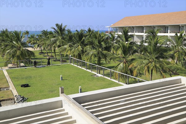 Amaya Beach Resort and Spa hotel, Pasikudah Bay, Eastern Province, Sri Lanka, Asia staff tending sedum grass roof garden, Asia