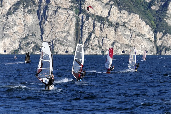 Windsurfers surfing in strong winds on Lake Garda near Malcesine, Veneto, Italy, Europe