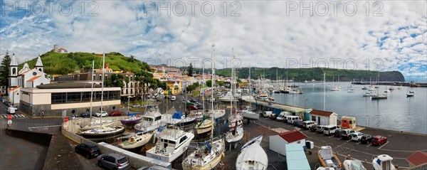 Wide angle shot of the harbour of Horta with boats, buildings and cars on the coastal road, Horta, Faial Island, Azores, Portugal, Europe