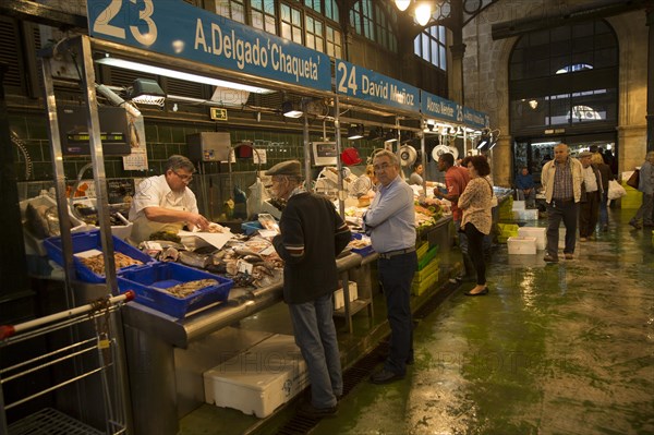 People shopping at fishmonger stalls inside historic covered market building, Jerez de la Frontera, Spain, Europe