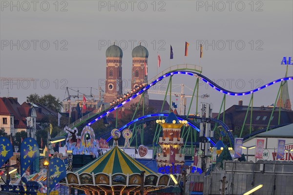 View over the Oktoberfest, in the evening with alpine railway in front of the Church of Our Lady, Munich, Bavaria, Germany, Europe