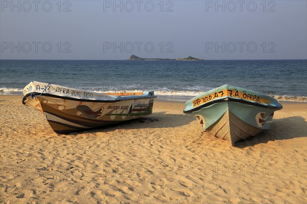 Boats on tropical beach at Nilavelli, Trincomalee, Sri Lanka, Asia with Pigeon Island in background, Asia
