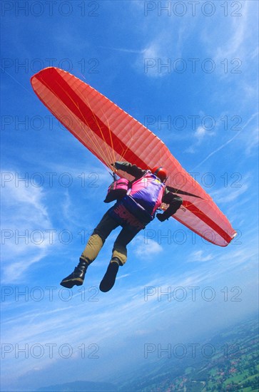 Paragliding pilot in a curve high above ground, camera on fishing lines fixed at the glider, Brauneck, Lenggries, Bavaria, Germany, Europe